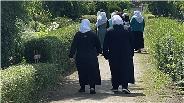 Eine Gruppe Muslimas geht durch die Naturglück-Kleingartensiedlung. Das Aufeinandertreffen von Kulturen ist Teil des Schrebergarten-Alltags.
