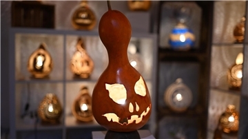 Eine handgefertigte Lampe aus einem Flaschenkürbis - mit Halloween-Fratze.