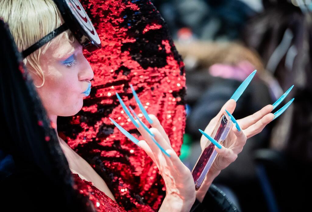 Berlin Fashion Week: Kilian Kerner mit politischer Botschaft Eine Herausforderung: Ein Model schaut im Backstagebereich vor der „Glück“-Show aufs Handy.