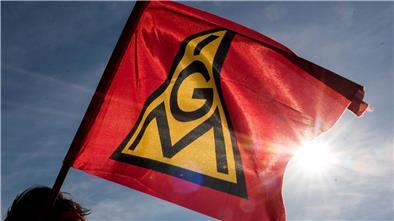 Eine IG-Metall-Fahne weht im Wind.