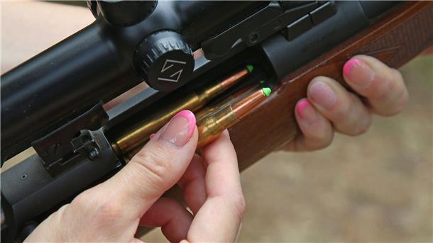 Eine Jägerin lädt ihre Jagdwaffe mit bleifreier Jagdmunition.