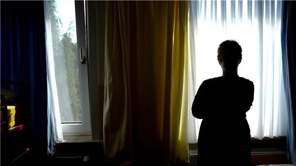 Eine junge Frau steht in einem Zimmer.