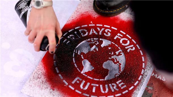 Bremer Fridays-For-Future-Gruppe abermalig gegründet Eine Klimaaktivistin sprüht ein „Fridays For Future“-Logo auf ein Transparent.