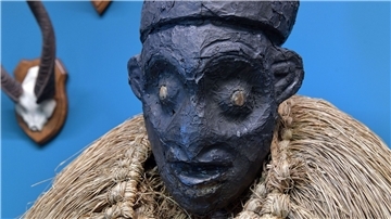 Eine Kopfaufsatzmaske aus Kamerun ist in einer Vitrine im Bremer Überseemuseum ausgestellt.