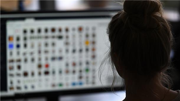 Eine Kriminaloberkommissarin sitzt in einem Büro vor einem Auswertungscomputer auf der Suche nach Kinderpornografie und Fällen von sexuellem Missbrauch.