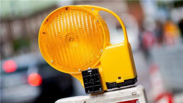 Bremer Regierung will Bauregeln vereinfachen Eine Leitbake mit einer Warnleuchte steht an einer Baustelle in der Innenstadt.