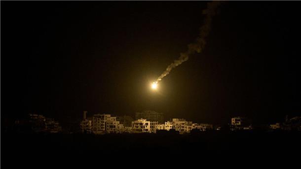 Bilder des Tages Eine Leuchtrakete der israelischen Armee fliegt über Gebäuden, die während der israelischen Boden- und Luftoperationen im nördlichen Gazastreifen zerstört wurden.