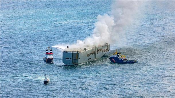 Eine Luftaufnahme zeigt einen deutschen Notschlepper(l), der das Feuer auf dem brennenden Frachter „Fremantle Highway“ bekämpft.