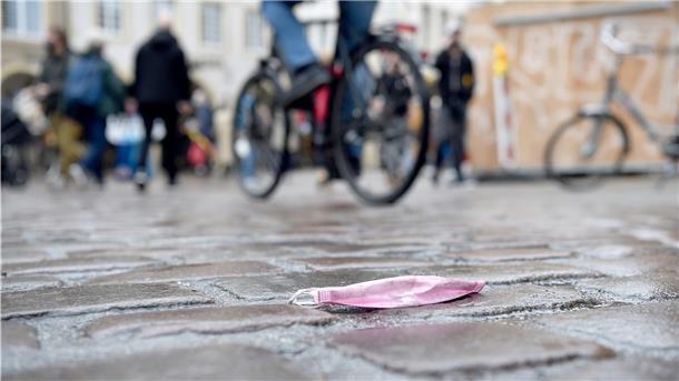 Eine Maske liegt in der Altstadt auf dem Kopfsteinpflaster.