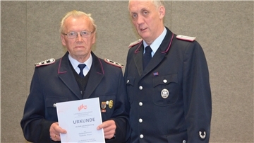 Eine nicht alltägliche Ehrung: Wilhelm Meyer (links) wird für 70 Jahre im Dienste der Feuerwehr geehrt. Die Urkunde überreicht Breddorfs Ortsbrandmeister Dietmar Mohrmann.