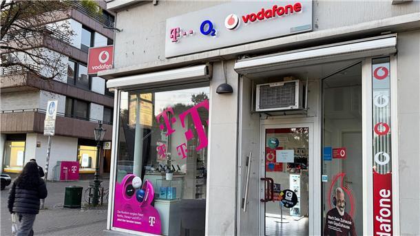Eine Passantin geht in einer Fußgängerzone an einem Shop vorbei, der Mobilfunkverträge der drei etablierten deutschen Netzbetreiber Telekom, Telefónica O2 und Vodafone anbietet. Im Wettkampf um die Kundengunst bieten nun alle drei Anbieter Privatkunden reines 5G an, auch 5G SA genannt.