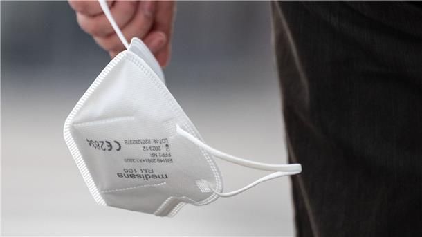 Millionen Masken wandern wohl in die Müllverbrennung Eine Passantin trägt eine FFP2-Maske in der Hand. Hunderte Million unbenutzter Masken müssen nun vom Bund entsorgt werden.