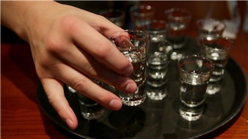 Eine Person greift nach einem gefüllten Schnapsglas. Mehr als zehn Millionen Menschen sterben laut der Weltgesundheitsorganisation (WHO) jedes Jahr durch Alkoholkonsum oder ungesunde Ernährung.