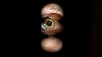 Eine Person schaut durch ein Schlüsselloch einer Tür. Auch Nachbarbarschaft kann zu Stalking ausarten (Symbolbild). Ein Betroffener berichtet vom jahrelangen Leiden seiner Familie.