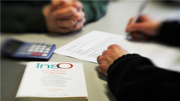 Eine Person sitzt in einem Beratungsgespräch bei der Schuldner- und Insolvenzberatungsstelle des Deutschen Roten Kreuzes.