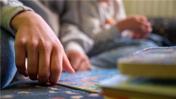 Tag der gewaltfreien Erziehung Eine Praktikantin liest in einer Kita Kindern vor..