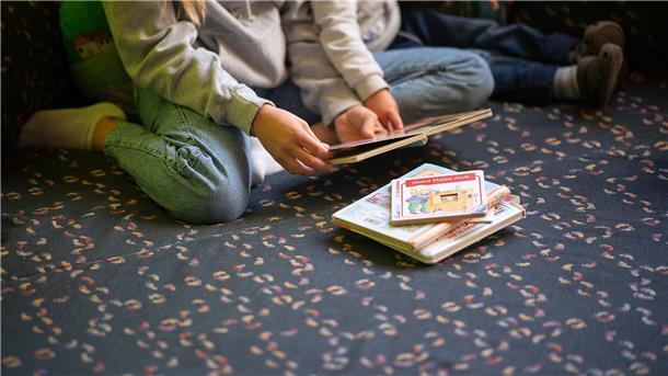 AfD fordert Verbot von Spielmethode „Original Play“ in Kitas Eine Praktikantin liest in einer Kita Kindern vor.