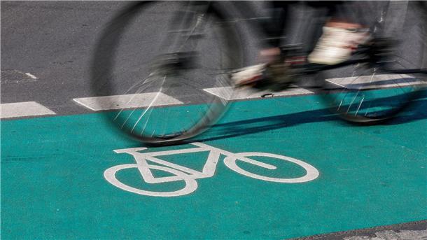 Kommunen sollen Fördergeld für Radverkehr abrufen Eine Radfahrerin fährt in Leipzig über einen grün eingefärbten Radweg.