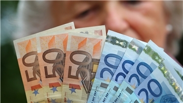 Eine Rentnerin hält verschiedene Euroscheine in ihren Händen.