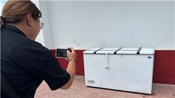 Eine Reporterin fotografiert die Kühltruhe, in der die Leiche des 62-jährigen Deutschen gefunden worden war. Nun hat die Polizei einen Verdächtigen festgenommen.