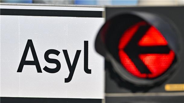 Eine rote Ampel leuchtet vor dem Wort „Asyl“.