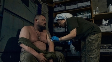 Eine Sanitäterin verarztet einen ukrainischen Soldaten in Bachmut.