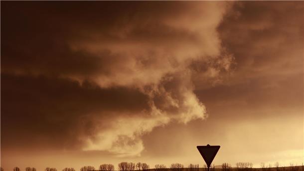 Eine Schlechtwetterfront zieht bei tief stehender Sonne über den Harz hinweg.