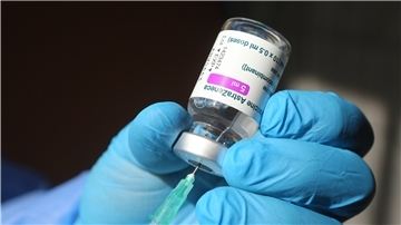 Eine Spritze wird mit dem Corona-Impfstoff von AstraZeneca aufgezogen.