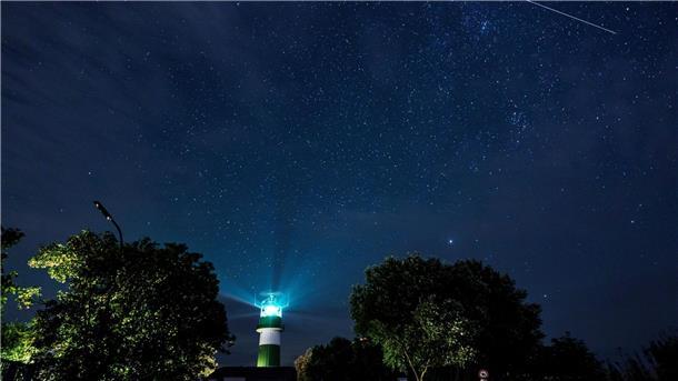 Sternschnuppenstrom der Perseiden erstrahlt am Wochenende Eine Sternschnuppe zieht über dem Leuchtturm Bülk am Ufer der Ostsee ihre Bahn.