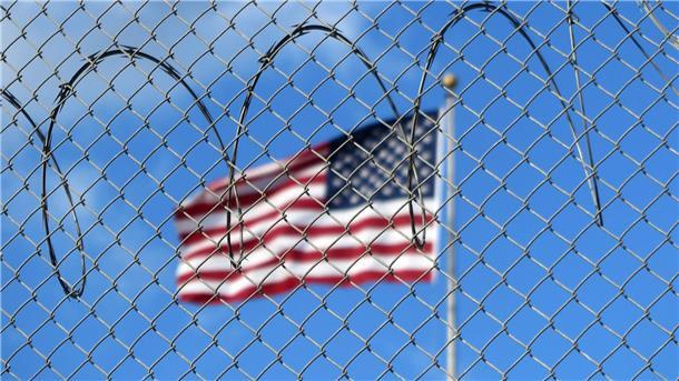 Die letzten Gefangenen von Guantánamo Eine US-Flagge hinter auf dem Marinestützpunkt Guantánamo Bay auf Kuba. Hier betreiben die USA seit mehr als 21 Jahren ein umstrittenes Gefangenenlager.