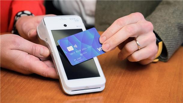 Konkretes Einführungsdatum für Asyl-Bezahlkarte noch unklar Eine VISA-Debit Karte wird bei einer Pressekonferenz im Rathaus Hannover vor ein Lesegerät gehalten.