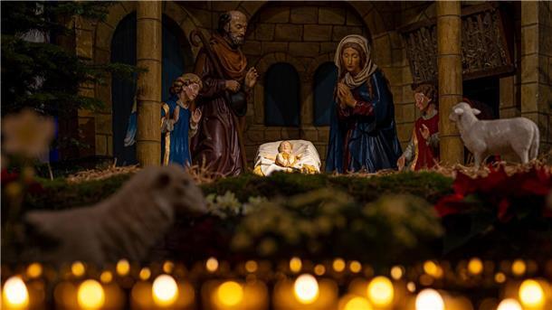 Landesbischof: Weihnachten als Auszeit nutzen Eine Weihnachtskrippe steht im Osnabrücker Dom hinter brennenden Kerzen.