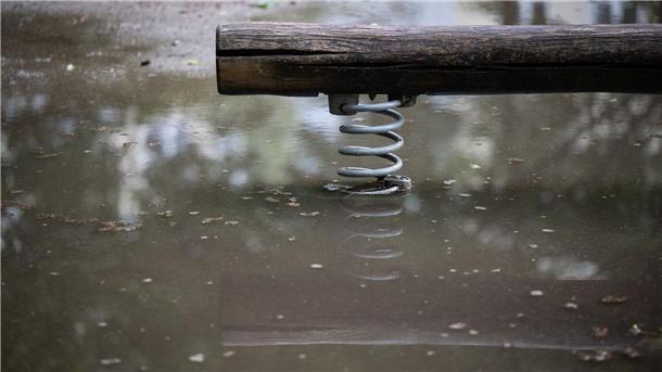 Eine Wippe auf einem Spielplatz steht im Wasser.