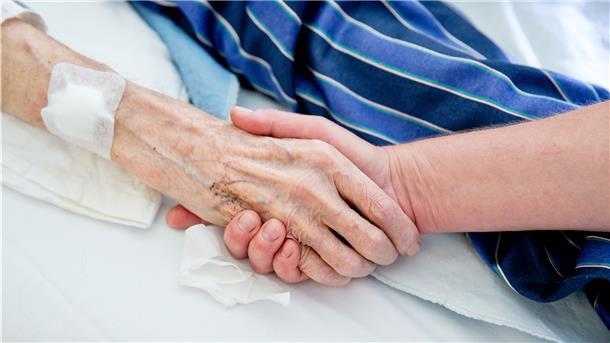 Einfach nur die Hand halten ist vielen Angehörigen in Zeiten von Corona-Kontaktsperren nicht möglich. Das Abschiednehmen ist deshalb sehr schwer.