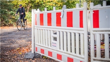 Radfahrer fährt an Baustelle vorbei.