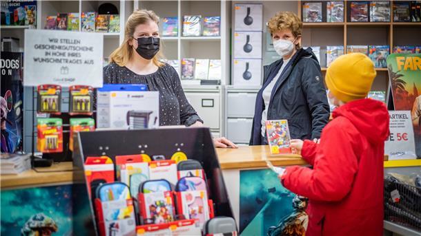 Einkaufsregeln unter Corona-Bedingungen für Kinder. Im Bild (von links): Astrid Engelbart vom Spielegeschäft Gameshop und Citymanagerin Claudia Bitti mit junger Kundschaft. Foto: Hartmann