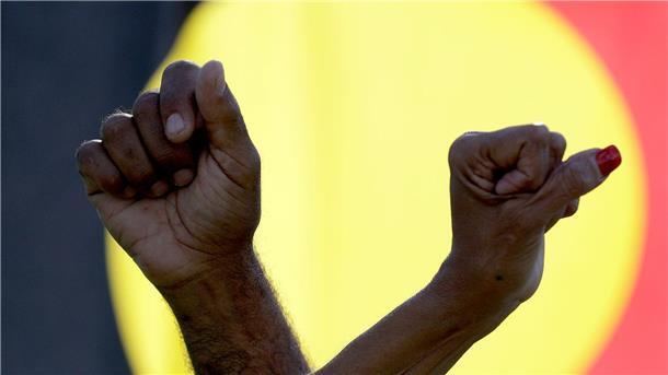 Immer mehr Zeitungen entschuldigen sich für dunkle Flecken Ein Mann und eine Frau verschränken die Arme vor einer Aborigines-Flagge während einer Kundgebung der Bewegung „Black Lives Matter“ in Sydney (Symbolbild). Der „Sydney Morning Herald“ hat sich für seine Berichterstattung zum Myall-Creek-Massaker entschuldigt.