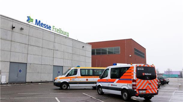 Einsatzfahrzeuge des Deutschen Roten Kreuz DRK und der Malteser stehen vor dem Gebäude der Freiburger Messe. Das dort eingerichtete Lazarett dient als Puffer für die überforderten Kliniken.