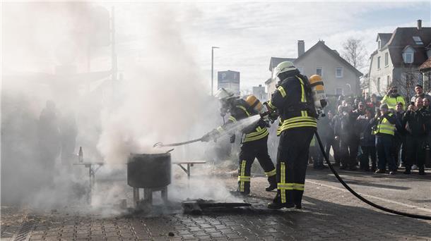 Einsatzkräfte der Feuerwehr löschen ein Feuer vor der Stadthalle.