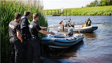 Einsatzkräfte der Polizei fahren bei der Suche nach dem vermissten Arian mit Spürhunden auf Schlauchbooten über die Oste.