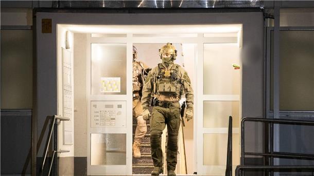 Zahlreiche Festnahmen bei Großrazzia gegen Schleuser-Bande Einsatzkräfte der Polizei verlassen ein Gebäude in Düsseldorf.