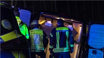 Einsatzkräfte stehen vor einem verunglückten Leichenwagen.