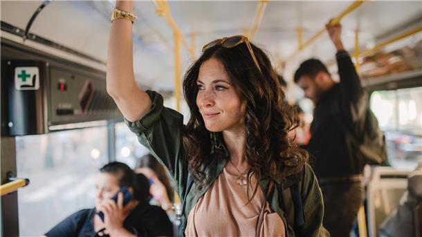 Große Stadt, kleiner Fußabdruck: Wie man umweltbewusst in einer Metropole lebt Frau steht im Bus
