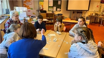 Elisabeth Epp und Lena Köhler arbeiten mit ukrainischen Flüchtlingskindern aus unterschiedlichen Jahrgängen in der Gosekamp-Grundschule Zeven: Mit Buchstabenkarten werden deutsche Worte zusammengelegt und gesprochen.