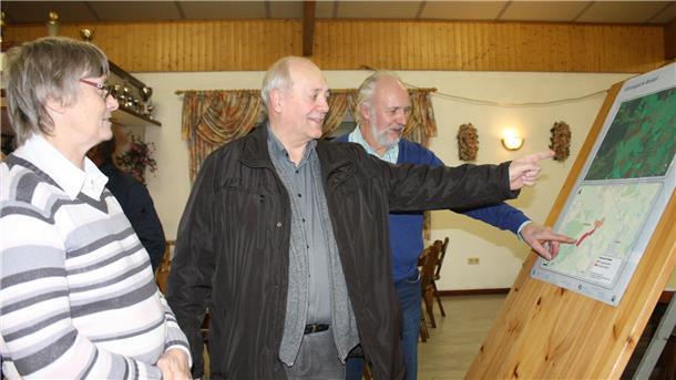 Elke Besser, Wilhelm Monsees und Udo Blümke (von links) sehen sich vor der Versammlung die Planungen für den geplanten Solarpark Bokel genau an.
