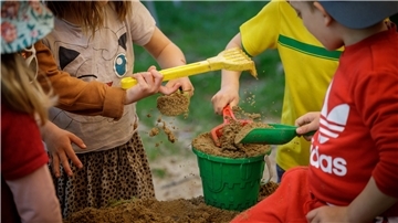 Kinder spielen mit Sandspielzeug in einem Sandkasten