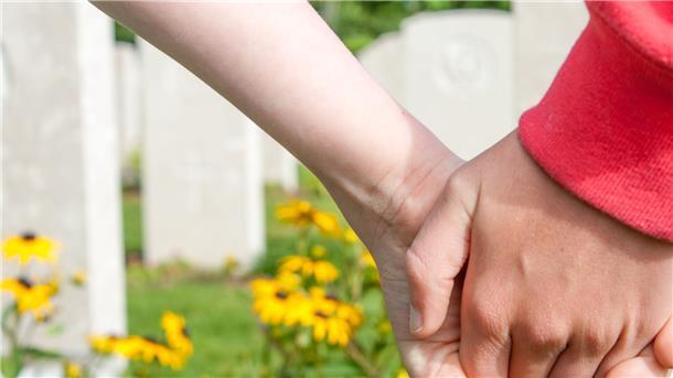 Eltern stehen auf einem Friedhof und halten sich an den Händen: Möglicherweise könnte es auch in Hepstedt bald eine Grabstätte für Sternenkinder geben.