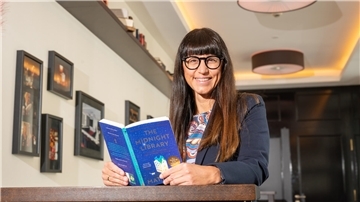 Eine Frau hält das Buch "Die Mitternachtsbibliothek" in der Hand. 