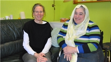 Emine Ramadan sitzt mit ihrer Sozialarbeiterin Birgit Hübner in ihrer Wohnung