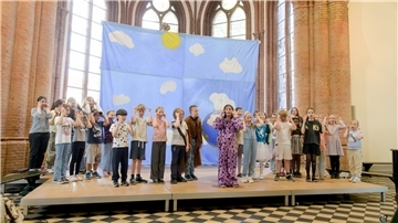 Mädchen und Jungen auf der Bühn vor dem Altar